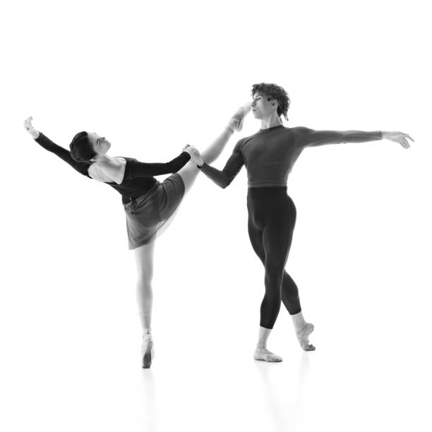 istock Elegance and strength. Ballet pair perfecting their routine against white studio background. Black and white filter. 2163060459