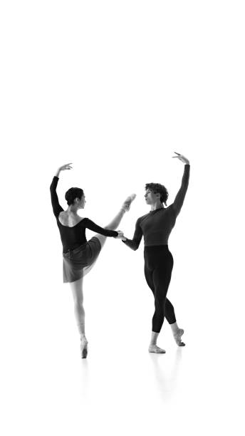 istock Elegance. Ballet duo harmonizes their movements during training against white studio background. Black and white filter. 2163060463