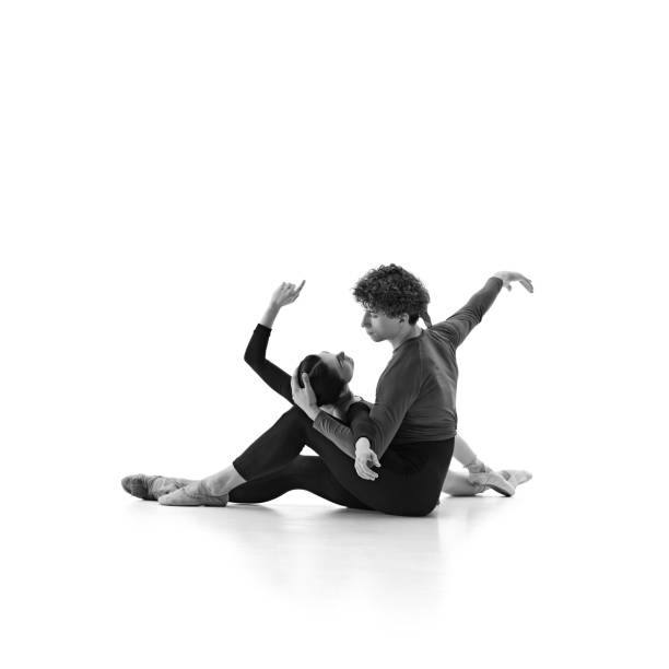 istock Ballet partners intertwine gracefully on floor shows connection and elegance in sync practice against white studio background. Sepia filter. 2163060486