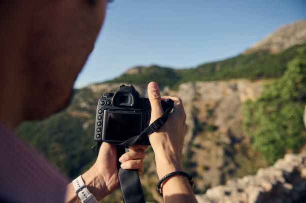 istock Photographer capturing scenic mountain landscape with digital camera 2163062203