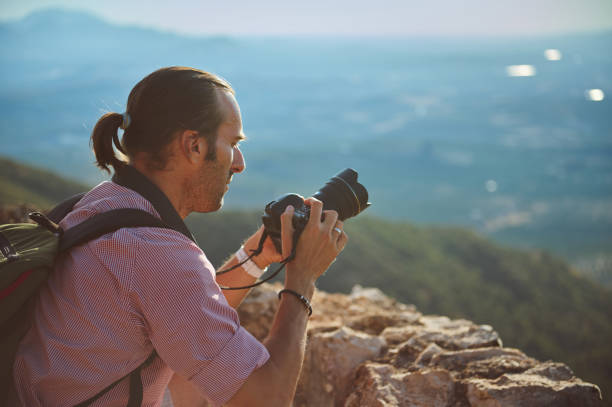 istock Photographer capturing stunning mountain landscape with professional camera during daytime 2163062904