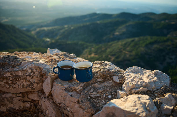 istock Two blue coffee mugs on a rock with a scenic mountain view in the background 2163062955