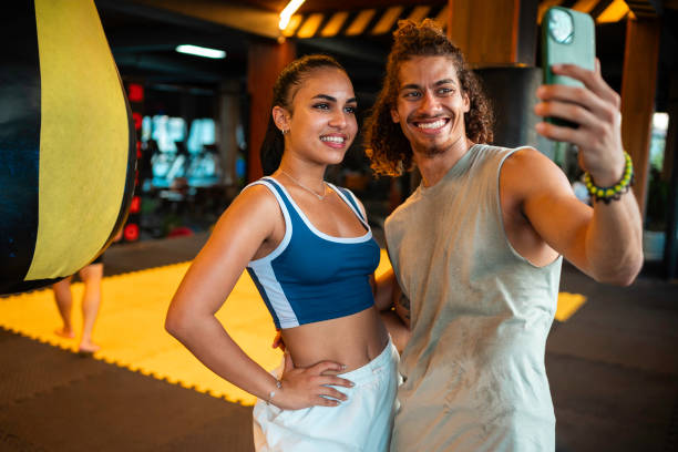 istock Young Hispanic Couple Smiling Taking Gym Selfie 2163063461