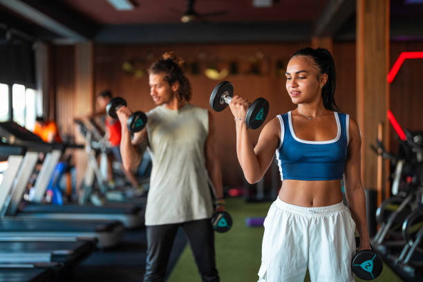 istock Hispanic Female Exercising With Dumbbells In Modern Gym 2163063472