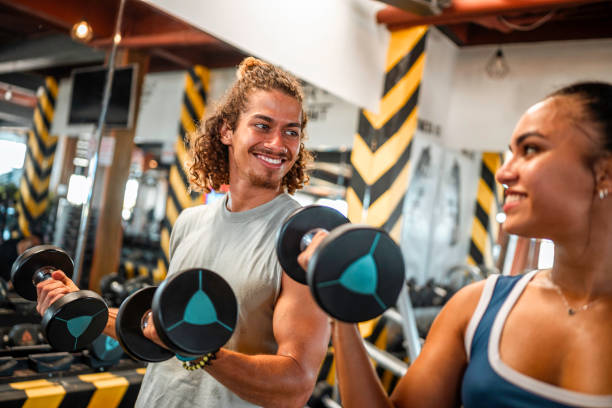 istock Diverse Young Adults Exercising With Dumbbells In Gym 2163064548