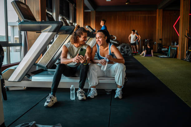 istock Smiling Hispanic Couple Taking Selfie In Modern Gym 2163064922
