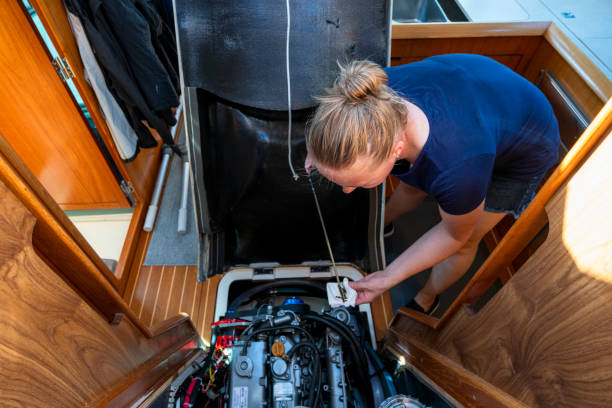 Woman maintains sailboat engine