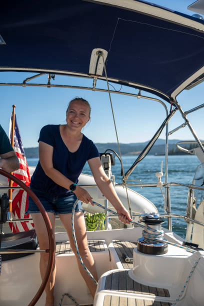 istock Woman pulls in rope on sailboat 2163066694