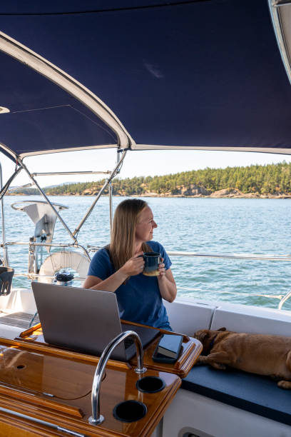 istock Woman works on computer aboard sailboat 2163066703