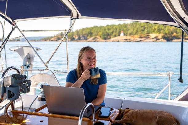 istock Woman works on computer aboard sailboat 2163066712