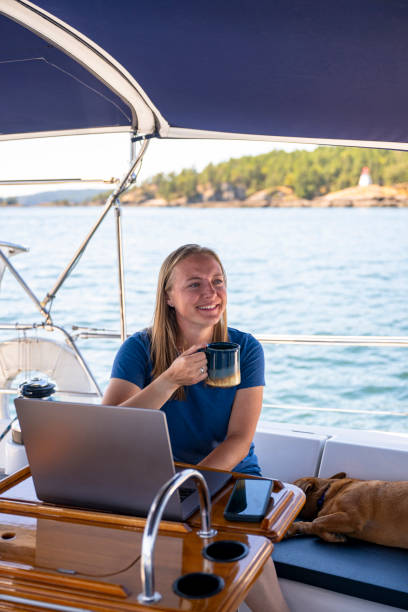 istock Woman works on computer aboard sailboat 2163066728