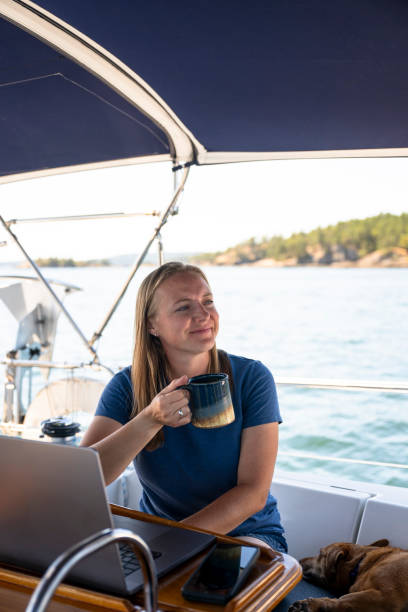 istock Woman works on computer aboard sailboat 2163066736
