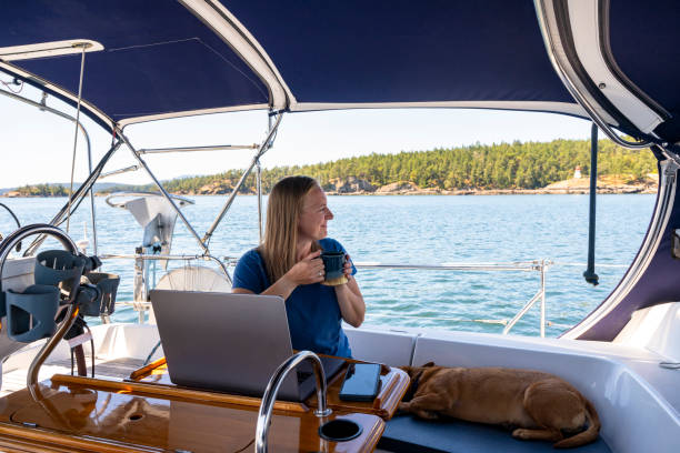 istock Woman works on computer aboard sailboat 2163066737
