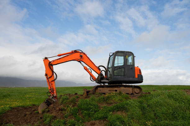 istock Orange excavator on a green meadow 2163066822