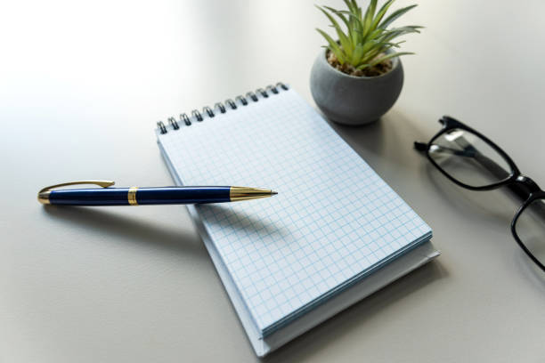blank notebook with pen, eyesglass on office white workplace. Space for your text. Business and education concept.