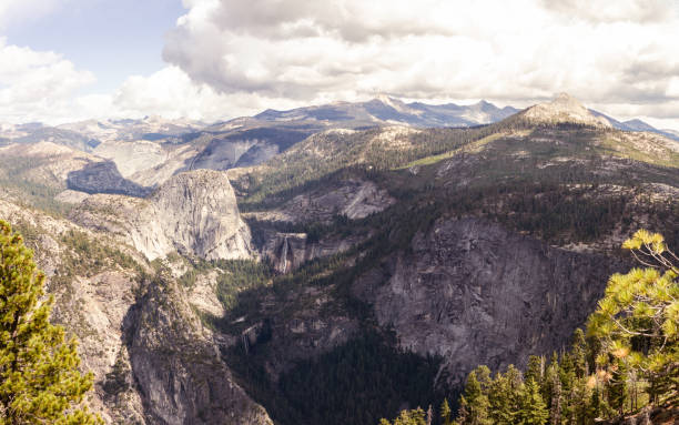 Landscape of Half Dome and white granite stone with waterfall and conifer trees, blue sky and clouds in Yosemite national park in California in America, usa
