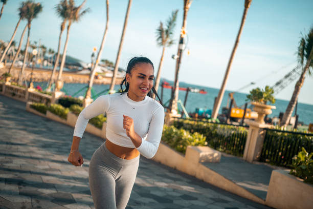 istock Active Hispanic Woman Jogging on Coastal Walkway 2163073890