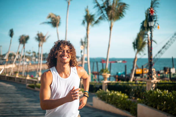 istock Active Hispanic Man Jogging by the Sea 2163073906