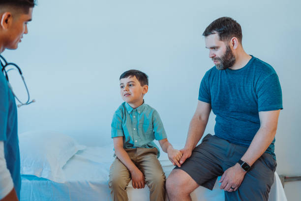 istock Young boy holds father's hand at the doctor's office 2163074617