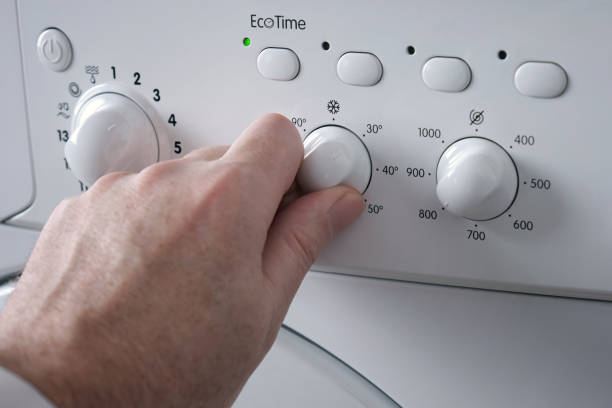 Unrecognisable man choosing program on washing machine - Image was taken in Europe, Serbia, city of Nis