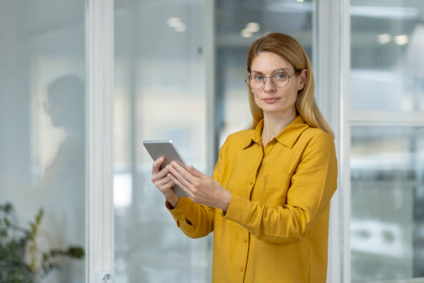 istock Confident professional woman using tablet in modern office environment 2163077561