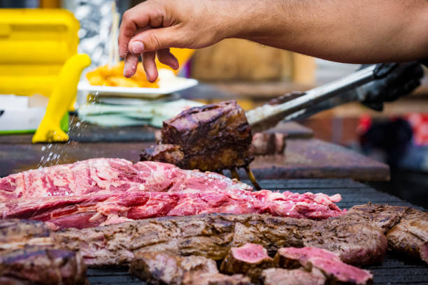 istock Man seasoning meat on grill 2163078500