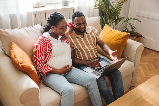 istock Loving pregnant couple using laptop at home 2163084248