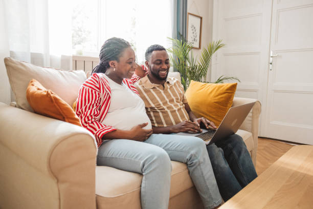 istock Loving pregnant couple using laptop at home 2163084270