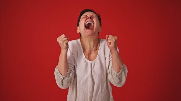 A funny fisheye image of a female with brunette hair laughing and cackling over something she finds funny.