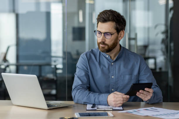 istock Serious accountant working on financial analysis using laptop in modern office 2163085935