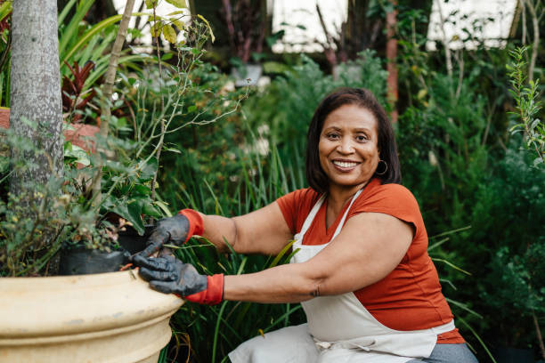istock Crouching woman taking care of plants 2163093155