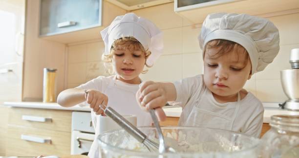 istock Budding Bakers: Children Measuring and Adding Flour for Baking in Slow Motion 2163093425