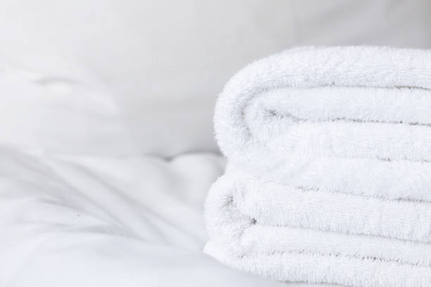istock White folded terry towels on a white sheet. 2163096271