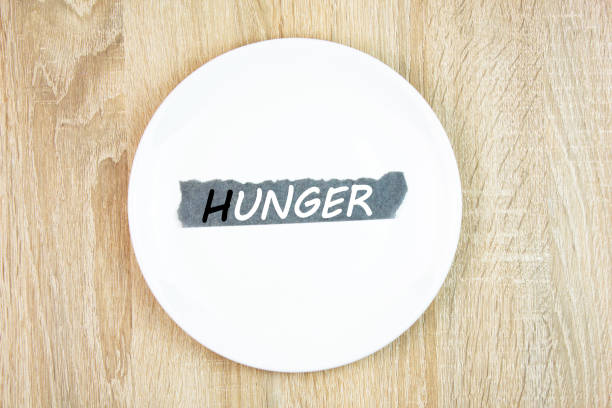 Hunger text,word on a plate on the table. White plate with a note hunger,global problem. Hunger concept.