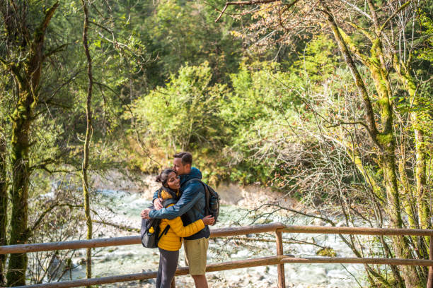 istock Multiracial Couple Embracing on Forest Hiking Trail 2163106120