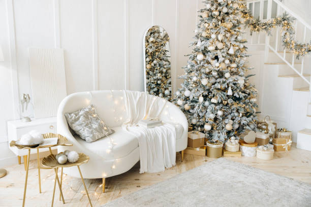 istock Room with Christmas decorations, white sofa adorned with lights, cozy blanket, Christmas tree decorated with ornaments, gold gift boxes, staircase, elegant and festive 2163112512