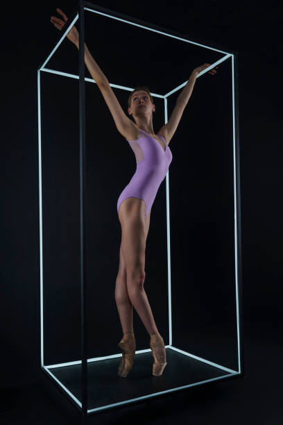 istock allerina in a photo studio on a black background in a light led cube shows ballet elements and stretching 2163115011