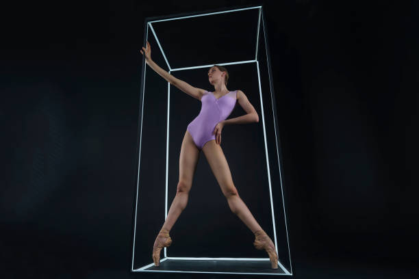 istock allerina in a photo studio on a black background in a light led cube shows ballet elements and stretching 2163115084