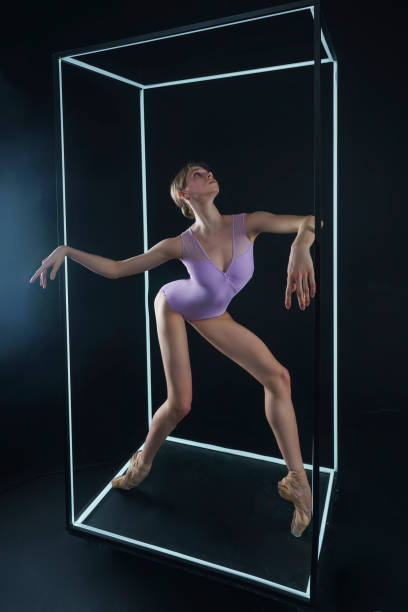 istock allerina in a photo studio on a black background in a light led cube shows ballet elements and stretching 2163115186