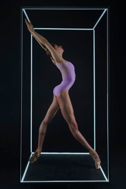 istock allerina in a photo studio on a black background in a light led cube shows ballet elements and stretching 2163115209