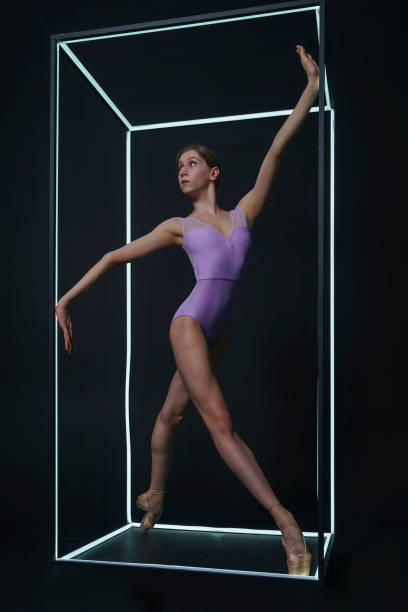 istock allerina in a photo studio on a black background in a light led cube shows ballet elements and stretching 2163115259