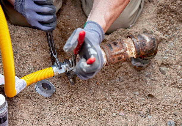 A Plumber hooking up a temporary gas line to a propane tank