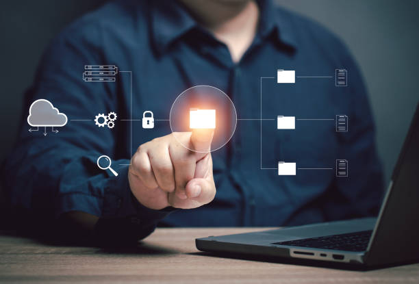 istock The user points to a folder at the virtual screen to work. Storing corporate work data in the online cloud. Database management for paperwork to paperless. Network security for company. 2163117289