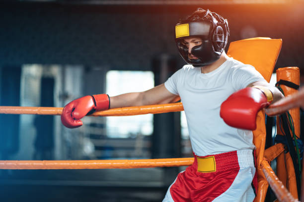 muscular boxer rest on ropes in corner ring for training next match