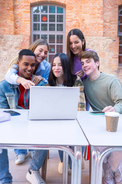 istock A group of students with laptops sit near the campus and communicate.Vertical 2163119921