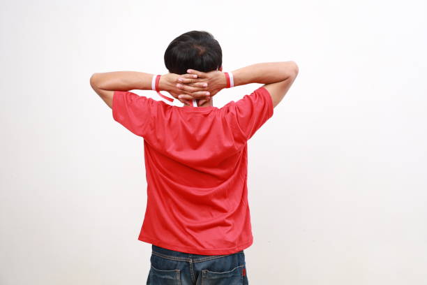 Young asian boy with red white ribbon celebrating Indonesia independence day while making thoughtful gesture