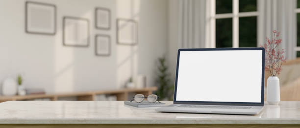 istock A laptop computer mockup, eyeglasses, and a book on a white marble table in a minimal white room. 2163131523
