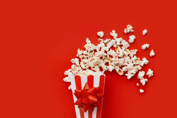 istock Striped box with popcorn with bow on a red background 2163133981