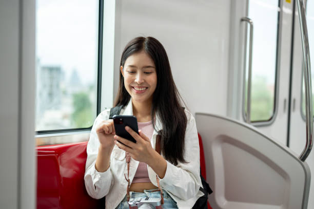 istock A beautiful Asian female traveler is using her smartphone while taking a sky train somewhere. 2163134521