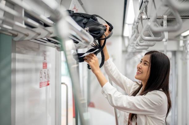istock A happy female is putting her backpack in an overhead luggage space while commuting on a sky train. 2163134564